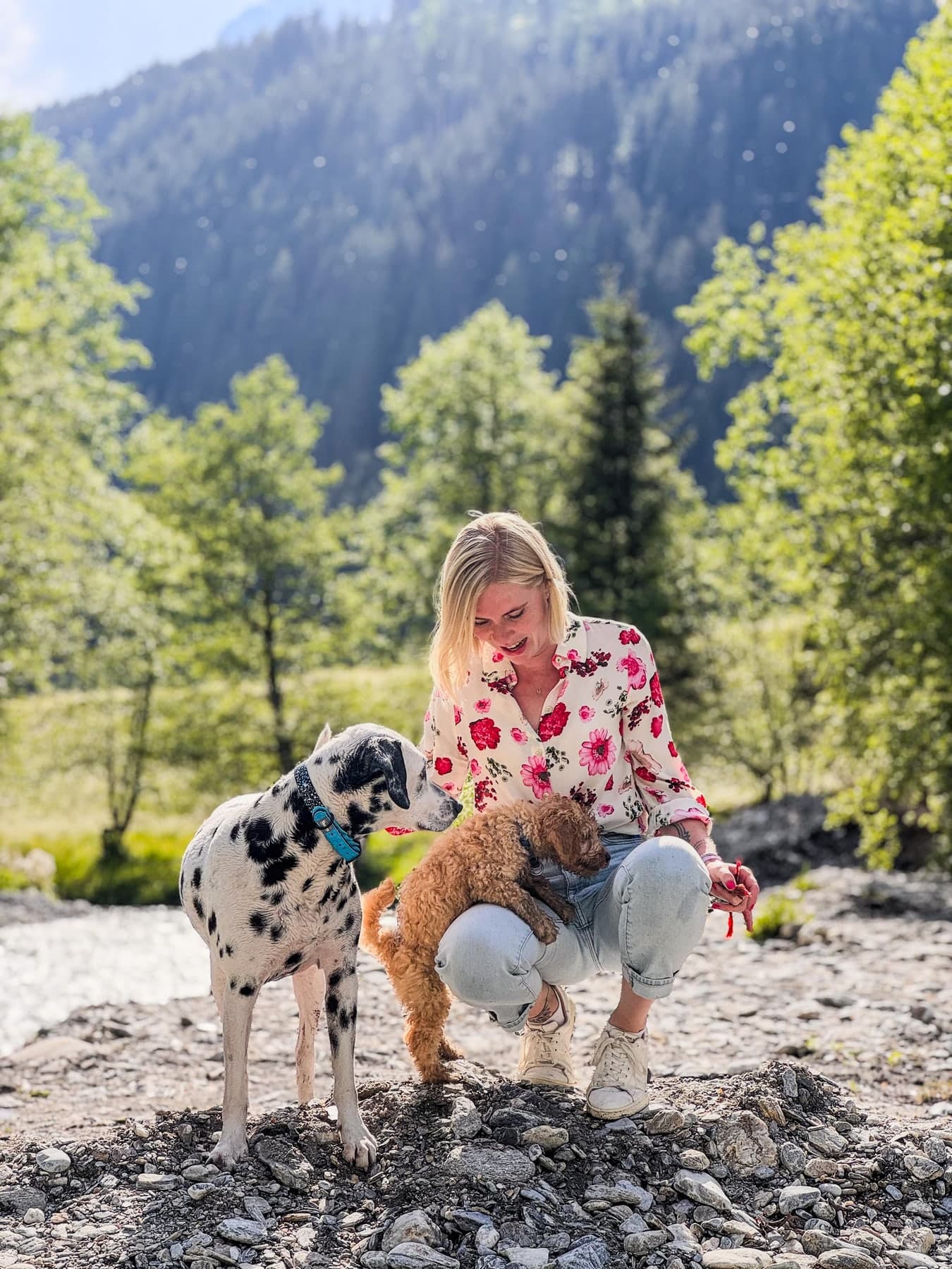 Melanie Ebster mit Dalmatiner und Pudel am Bachbett im Zillertal