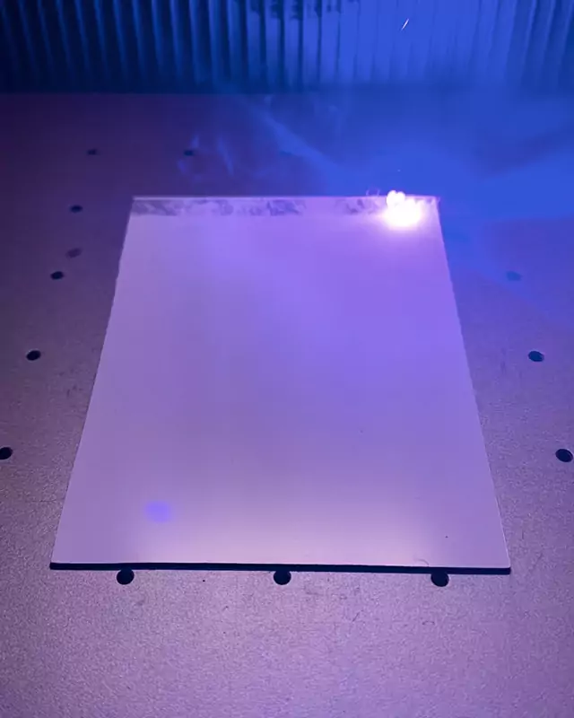 Der Laser graviert ein Foto Zeile für Zeile in eine Metallplatte